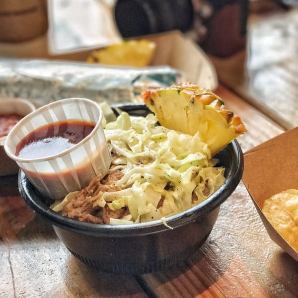 Kono's pulled pork bowl with coleslaw, pineapple, and a side of BBQ sauce.