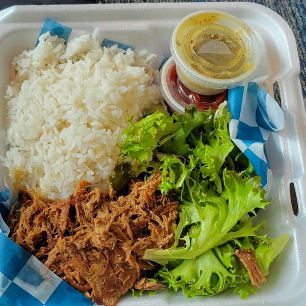 Kono's Hawaiian plate lunch with shredded pork, white rice, green salad, and two sauce cups.