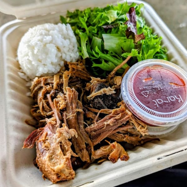 Kono's Hawaiian pulled pork plate with rice, green salad, and a side of sauce.