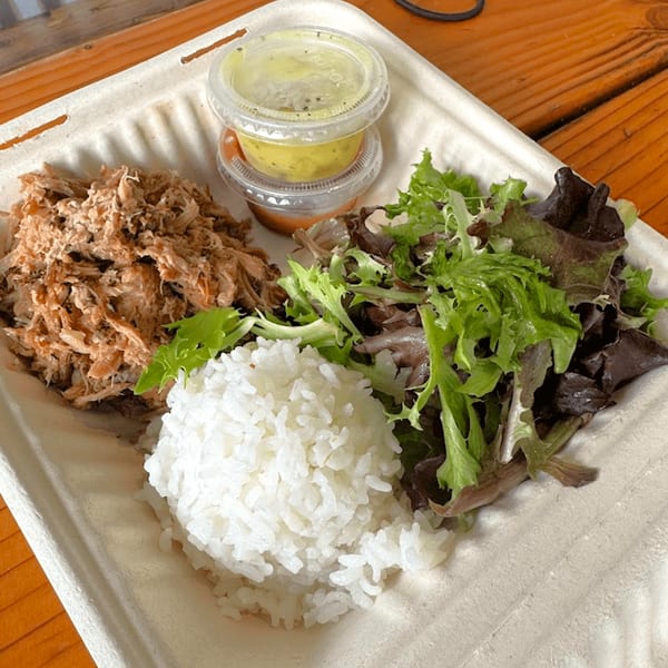 Kono's Hawaiian plate lunch with kalua pig, white rice, mixed greens, and two sauces.