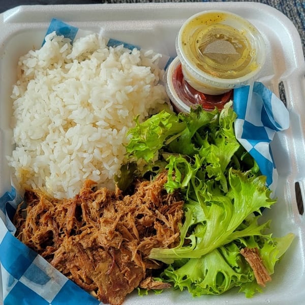 Kono's Hawaiian plate lunch with shredded pork, white rice, green lettuce, and two sauce containers.