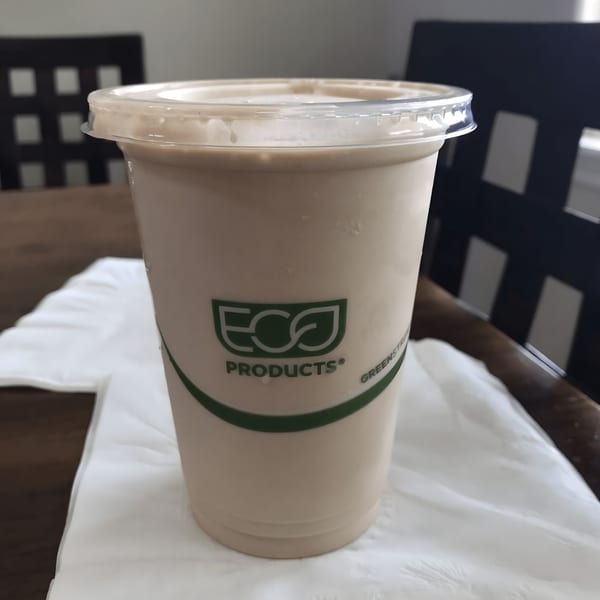 A Kono's smoothie in a clear cup with an "Eco Products" logo, on a white napkin.